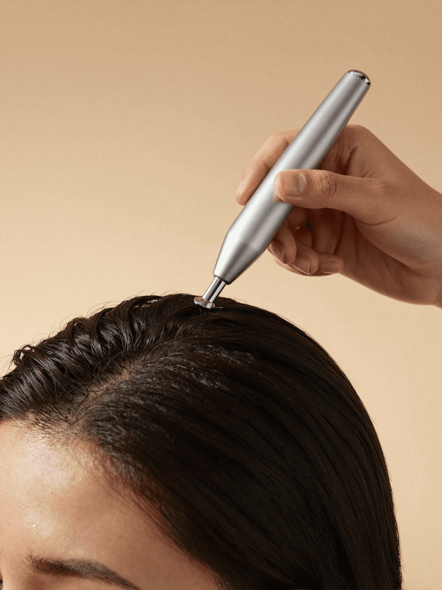 A therapist closely examining a client's scalp under soft light during a Japanese head spa analysis